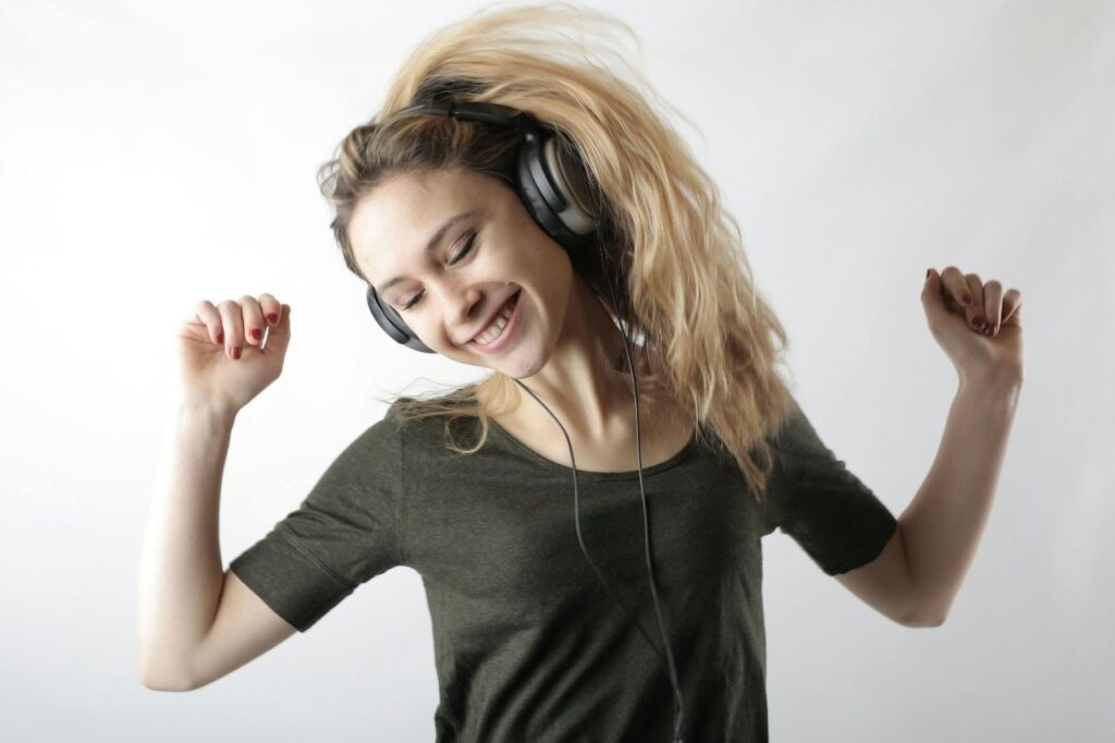 Happy creator enjoying royalty free music with headphones and dancing freely