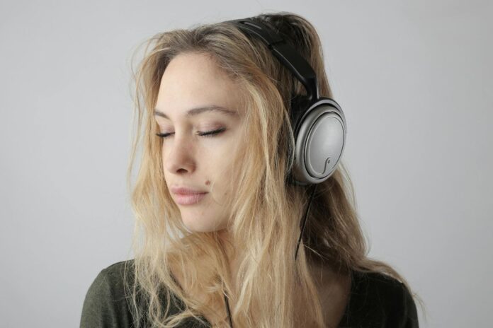 Woman wearing headphones listening to royalty free music calmly