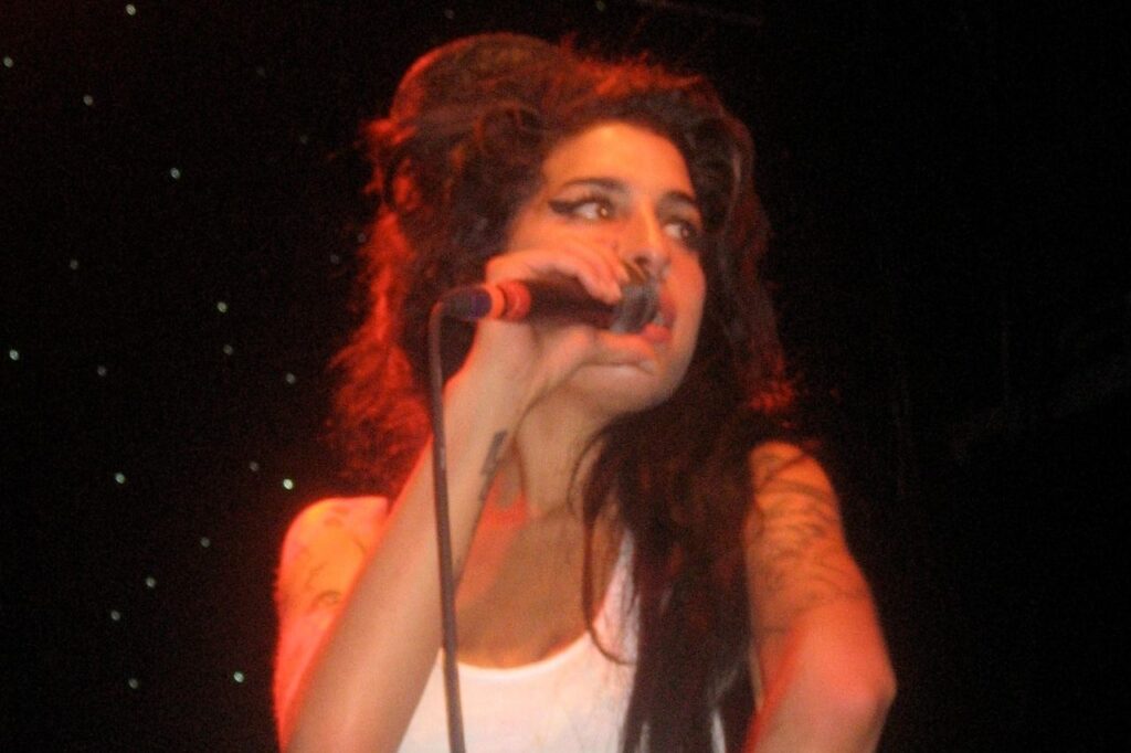 Amy Winehouse performing live, remembered for her soulful voice and timeless legacy.