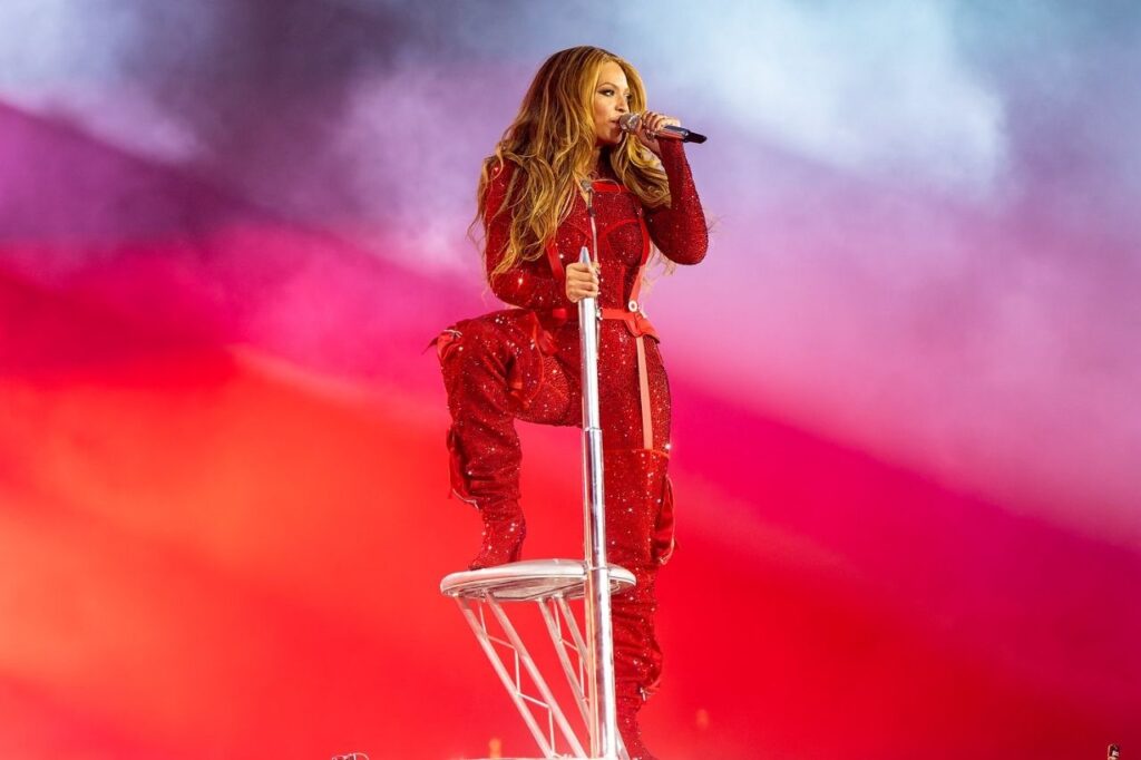Beyoncé performing live in London in a sparkling red outfit during her world tour, an unforgettable moment featured in Beyoncé Biography celebrating her music and stage energy.
