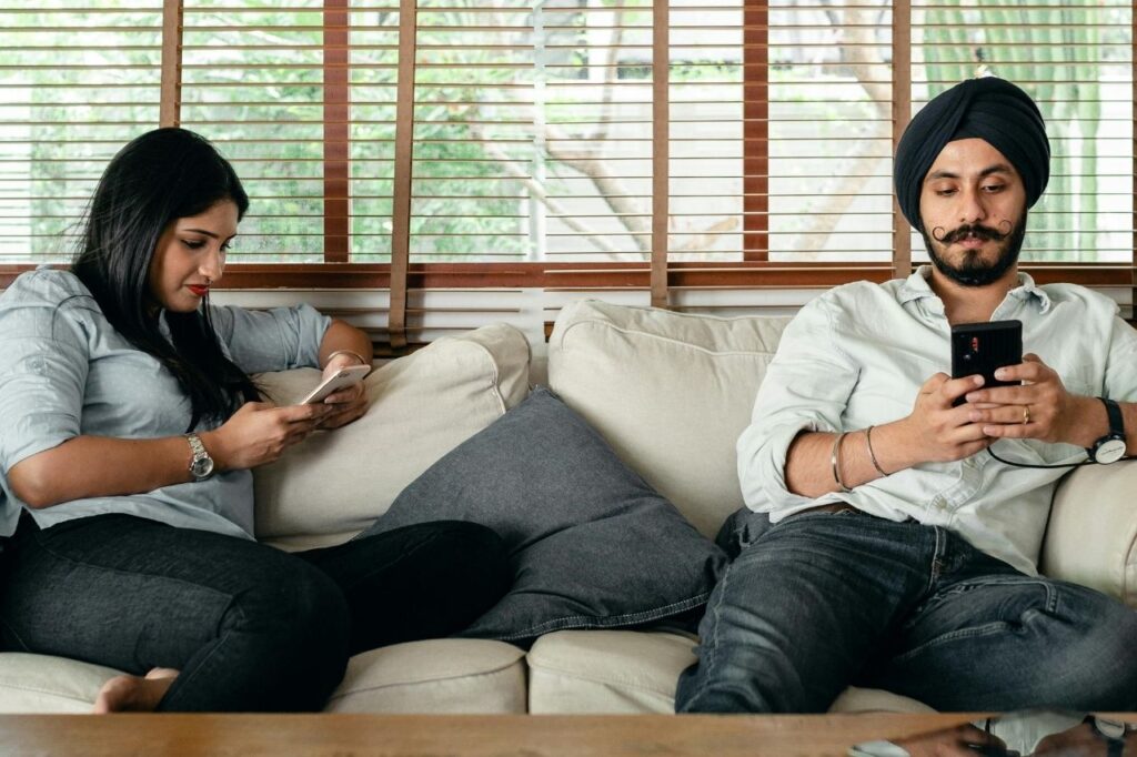 Couple using smartphones to stream Disney Hotstar OTT content at home