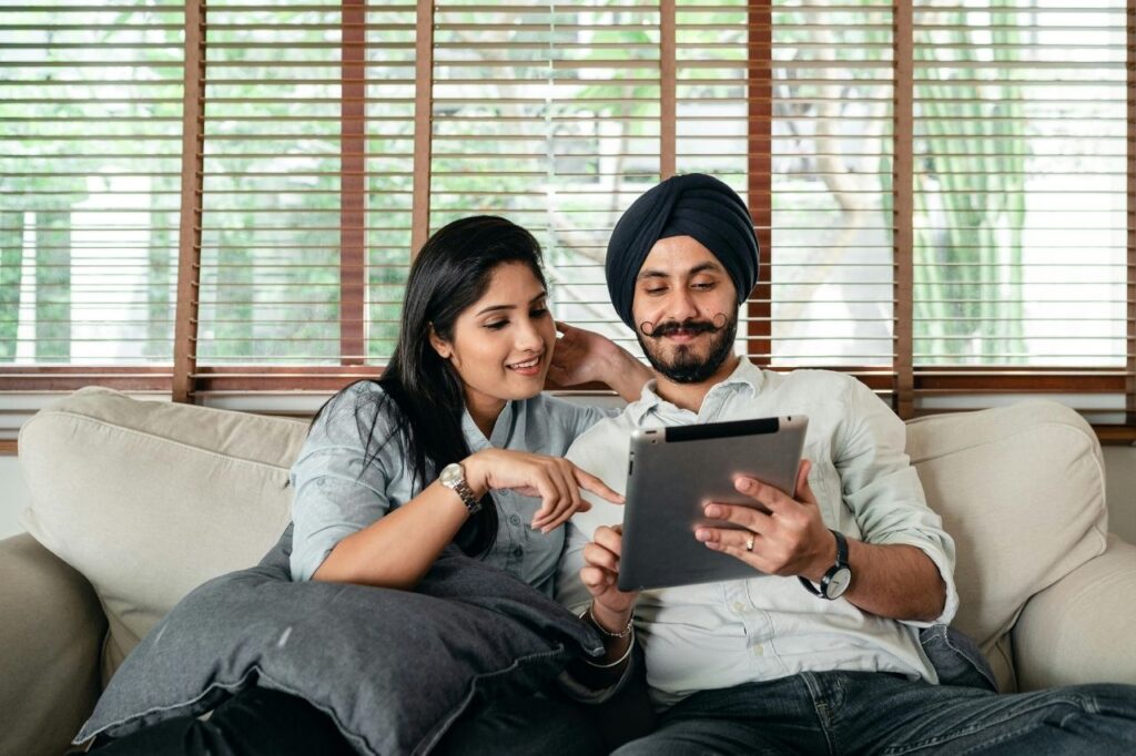 Couple watching Disney Hotstar on tablet discussing subscription plans