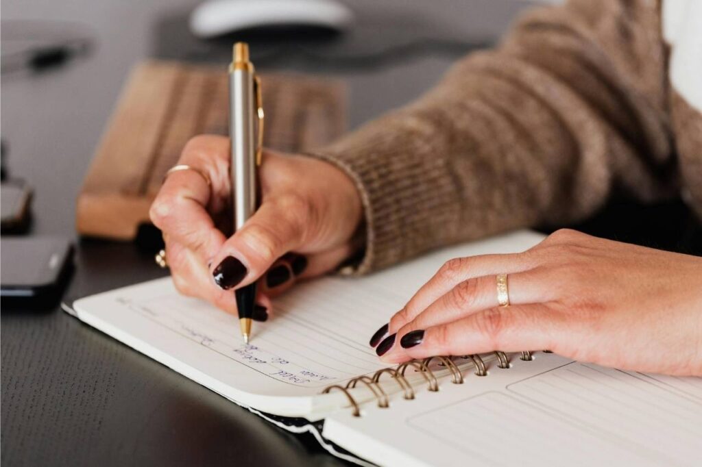 A person practicing English writing in a notebook to improve writing skills.