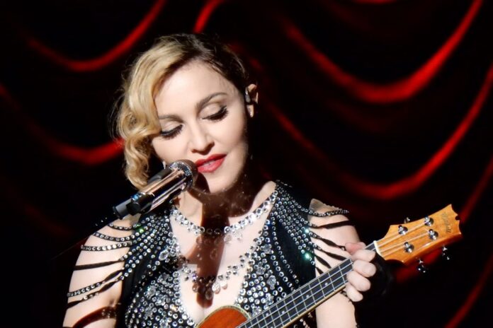 Madonna performing live on stage during her concert, showcasing her energy and iconic style