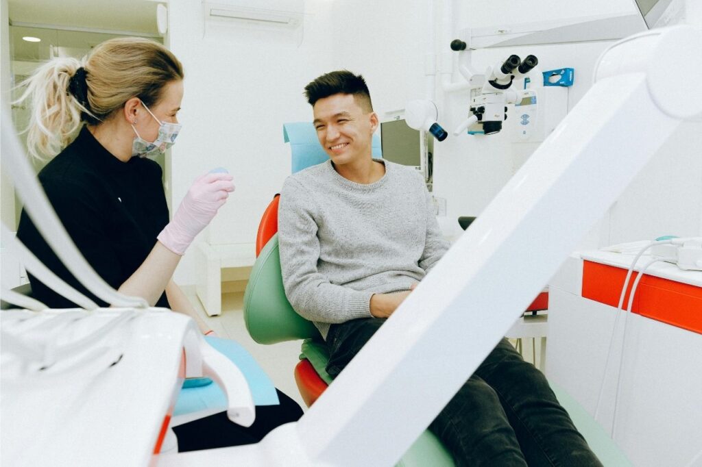 A dentist discussing smile veneer options with a patient during consultation.