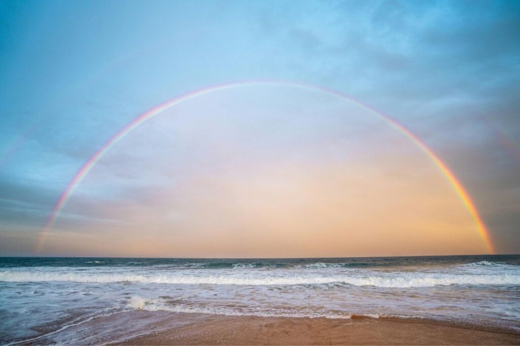 Rainbow over the ocean symbolizing peace and hope from the song Somewhere Over the Rainbow.